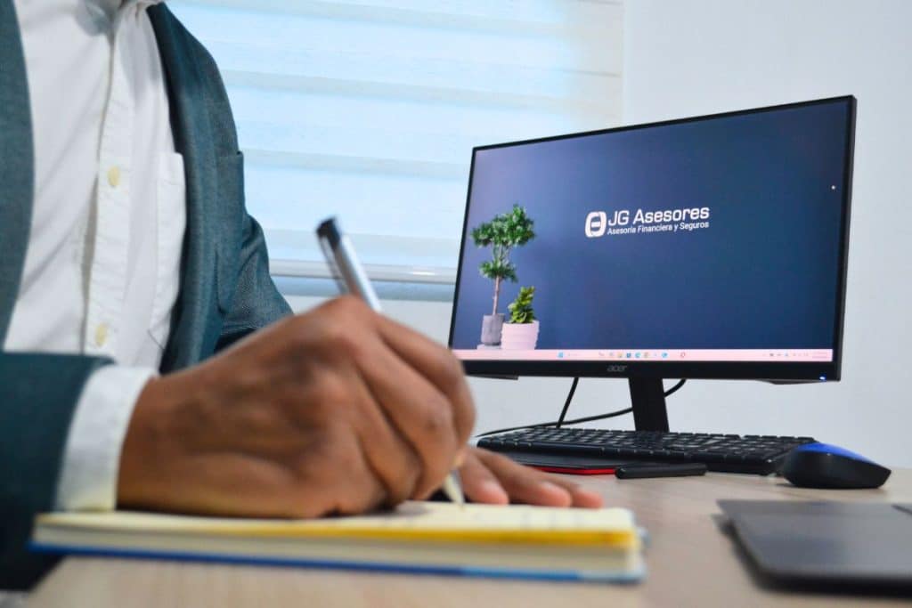 Fondo de JG Asesores con mano firmando una hoja